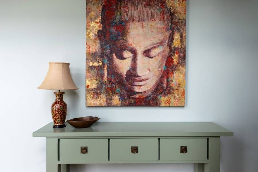 picture of a face hangin in a hallway over a table